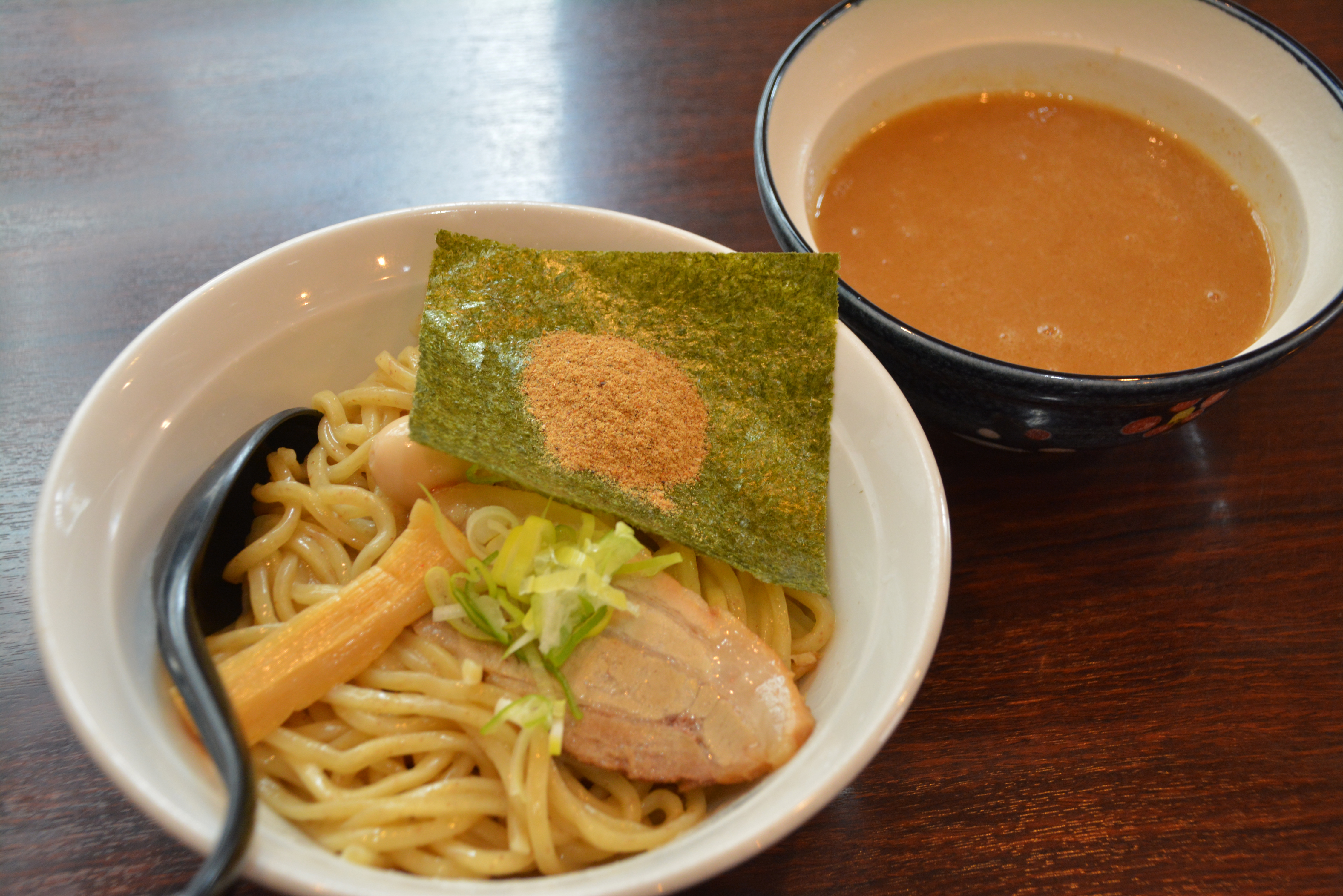 A bowl of tsukemen dipping noodles with thick noodles, chashu, menma and a separate rich broth